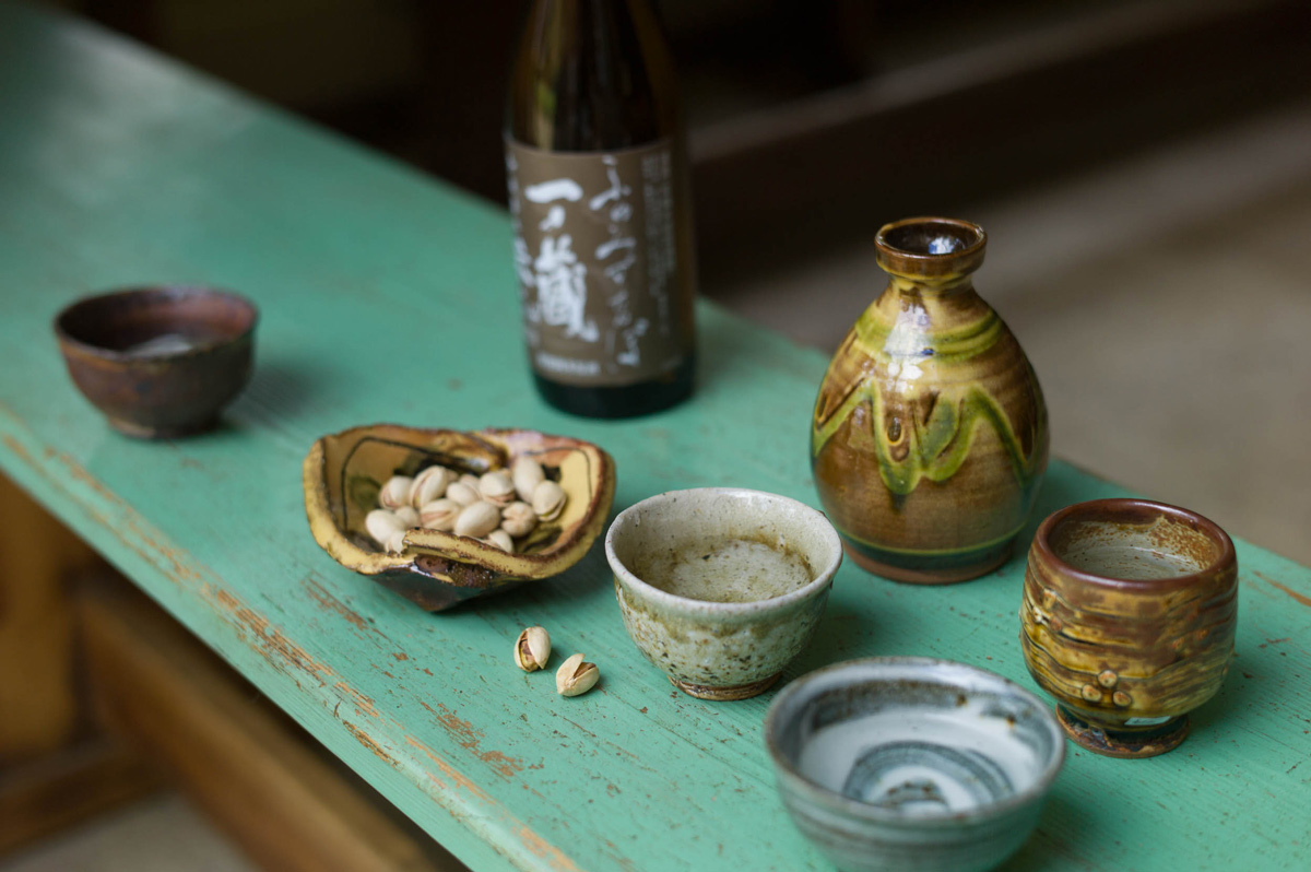 Sake with bottle by Clive Bowen, guinomi by Phil Rogers, Nic Collins & Mike Dodd, and pistachios in a dish by Jean-Nicolas Gérard