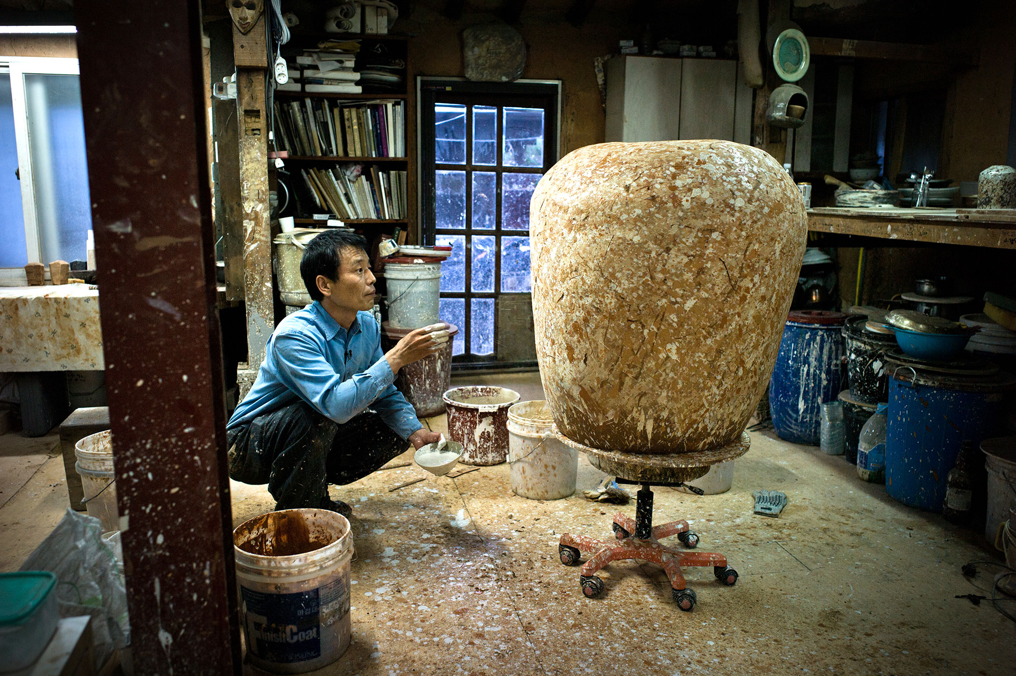 Lee Kang-hyo decorating a giant onggi jar in his studio in Korea