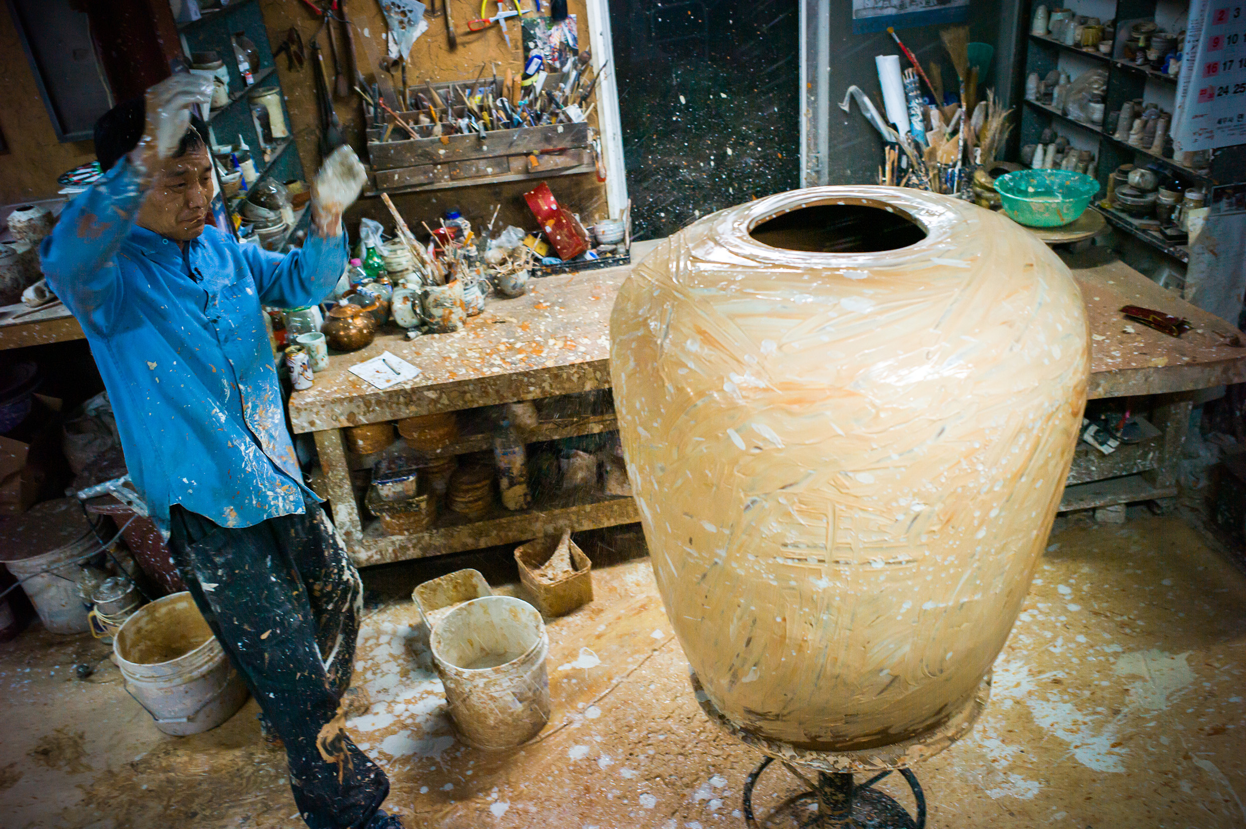 Kang Hyo Lee decorating a giant Onggi jar at his studio in South Korea photographed by Jay Goldmark Kang-hyo Lee, In Conversation 